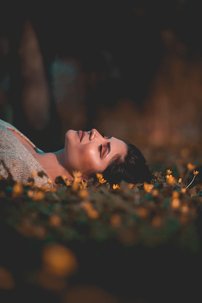 花に囲まれて眠る女性