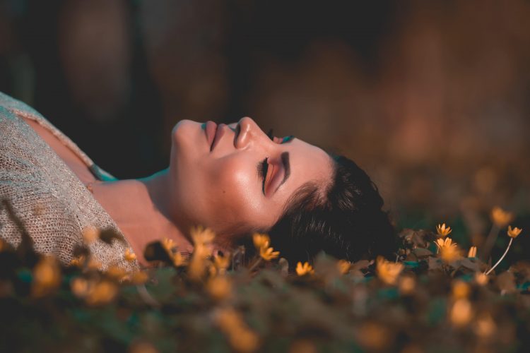 花に囲まれて眠る女性